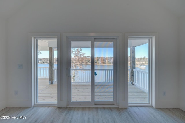 13 E Cannon Cv, Hampstead, NC 28443 - doorway to outside with a water view, lofted ceiling, and light wood finished floors