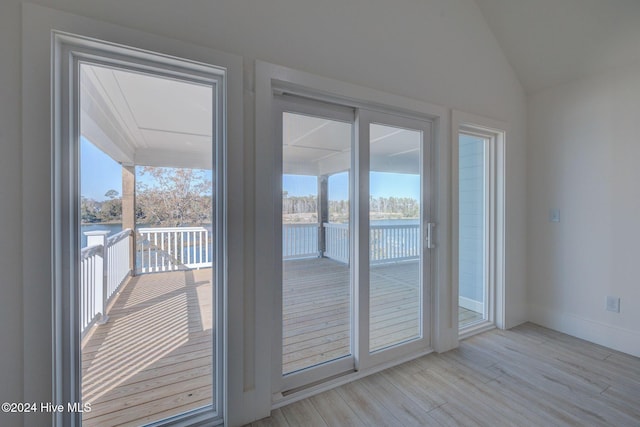 doorway featuring a water view and light hardwood / wood-style flooring