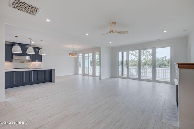 unfurnished living room featuring ceiling fan and light hardwood / wood-style floors