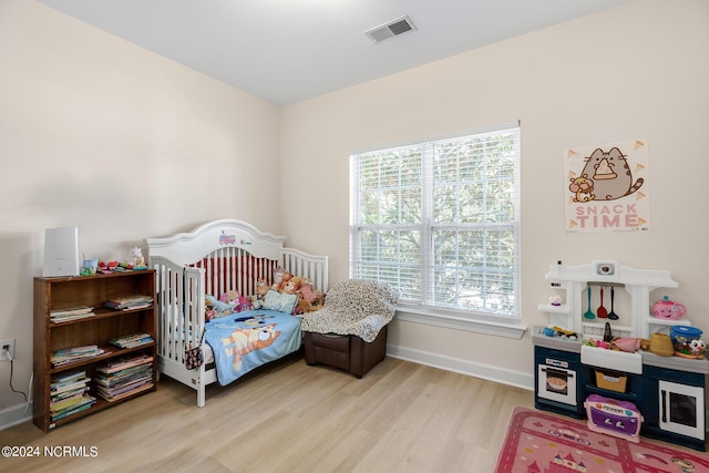 bedroom featuring baseboards, visible vents, and wood finished floors