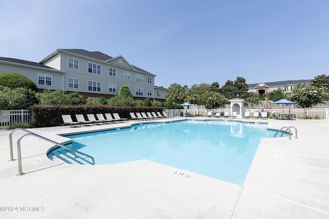 pool with fence and a patio