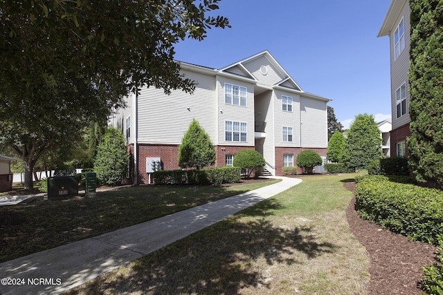 view of front of home featuring a front lawn and brick siding