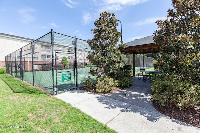 view of sport court featuring a lawn