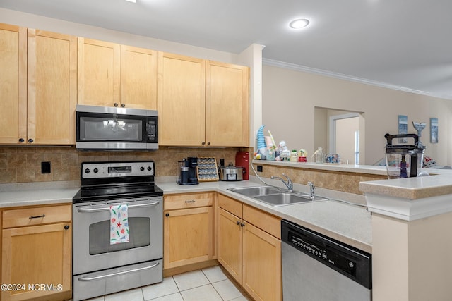 kitchen with light brown cabinets, a peninsula, appliances with stainless steel finishes, and a sink