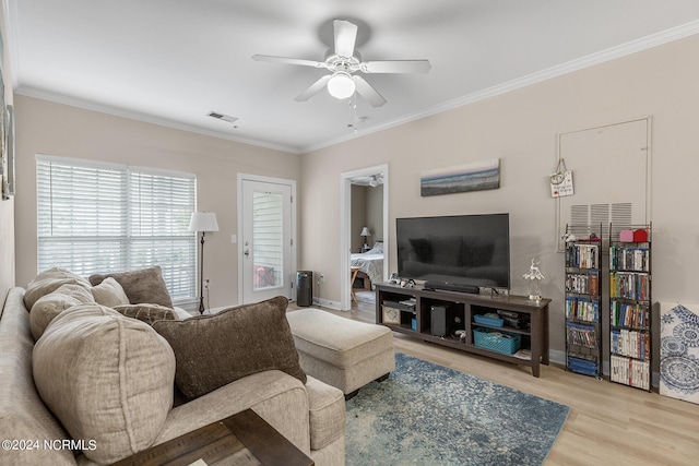 living room with baseboards, visible vents, ceiling fan, wood finished floors, and crown molding