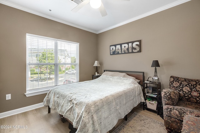 bedroom with baseboards, ceiling fan, wood finished floors, and crown molding