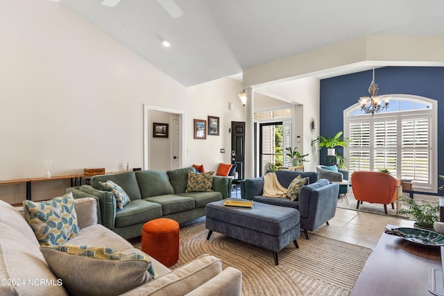 tiled living room with decorative columns, high vaulted ceiling, and a chandelier