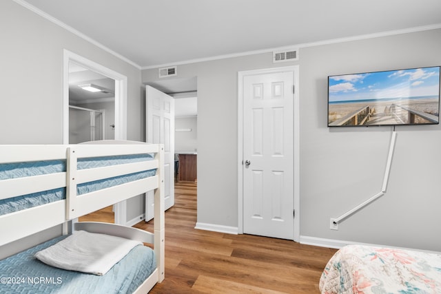 bedroom featuring hardwood / wood-style flooring and crown molding