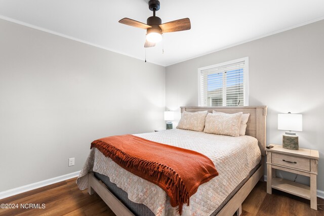 bedroom featuring dark hardwood / wood-style flooring, crown molding, and ceiling fan