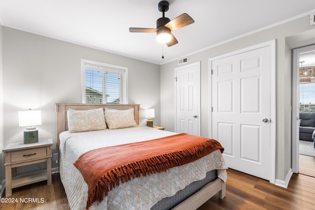 bedroom with ornamental molding, dark hardwood / wood-style floors, and ceiling fan