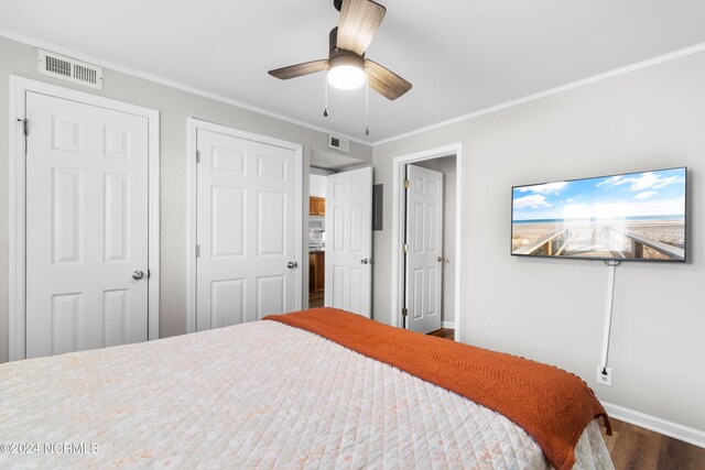 bedroom featuring hardwood / wood-style floors, ornamental molding, and ceiling fan