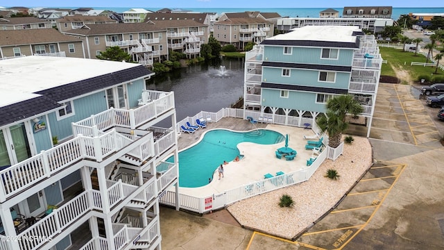 view of swimming pool with a patio area and a water view