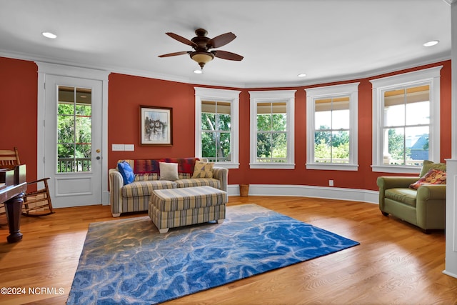 living room featuring ceiling fan, light hardwood / wood-style flooring, and ornamental molding