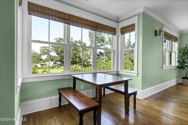 dining room featuring plenty of natural light, crown molding, and hardwood / wood-style flooring