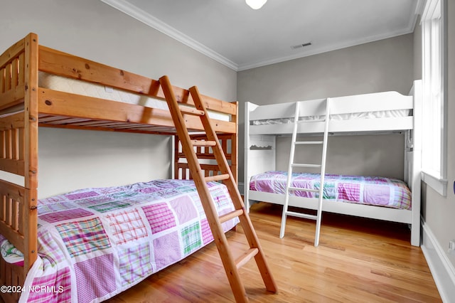 bedroom with wood-type flooring and crown molding