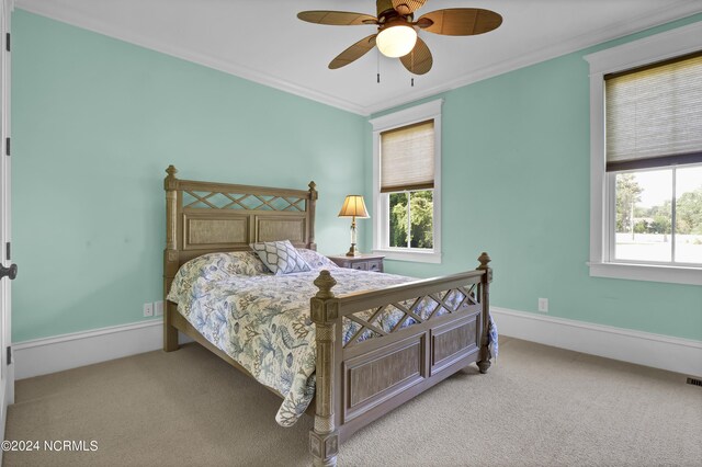 bedroom with ceiling fan, ornamental molding, and light colored carpet