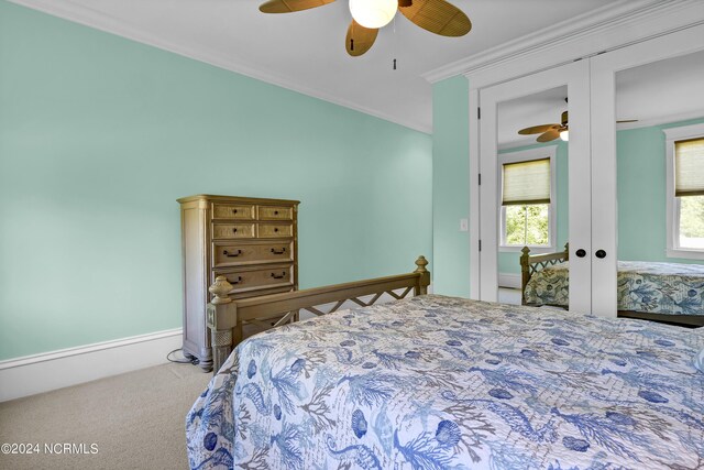 carpeted bedroom with ceiling fan, french doors, a closet, and ornamental molding