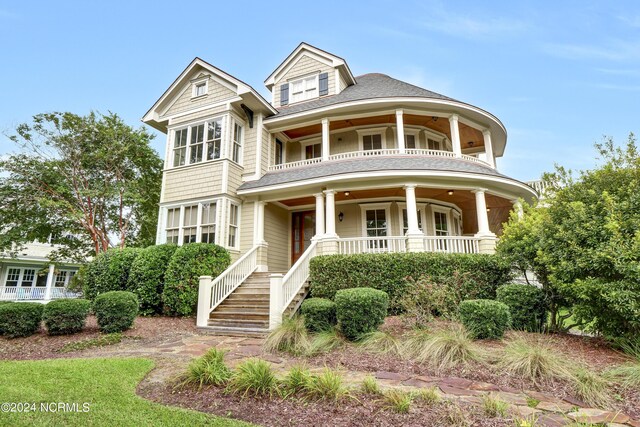 victorian-style house featuring a porch and a balcony