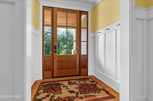 entryway featuring light wood-type flooring and ornamental molding