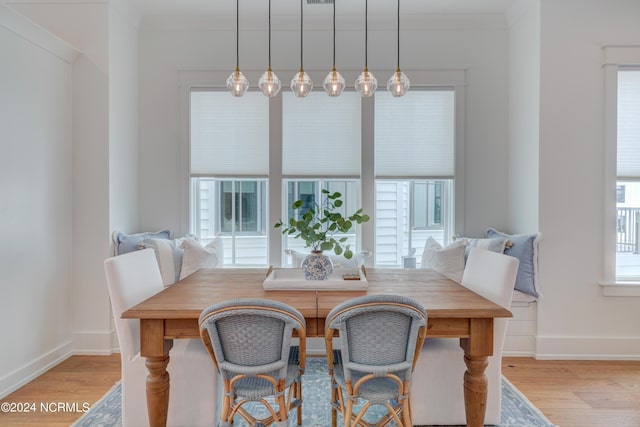 dining area featuring breakfast area, light wood-type flooring, a healthy amount of sunlight, and baseboards