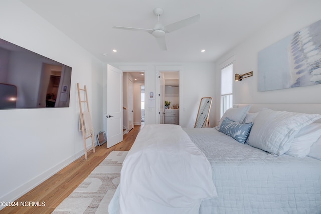 bedroom featuring light wood finished floors, baseboards, ceiling fan, a spacious closet, and recessed lighting