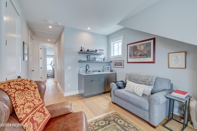 living area with attic access, baseboards, wet bar, light wood-type flooring, and recessed lighting