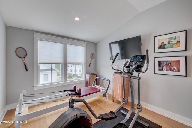 workout room with lofted ceiling, light wood-type flooring, and baseboards