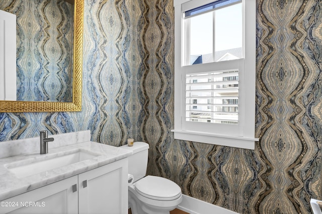 bathroom featuring plenty of natural light, vanity, and toilet