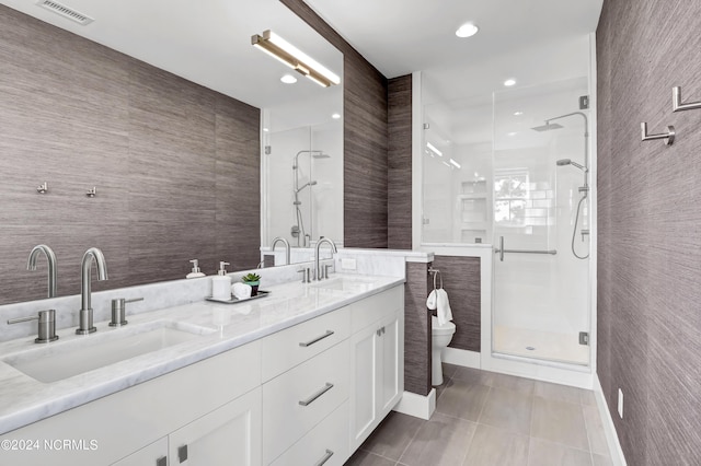 bathroom featuring tile patterned floors, a sink, visible vents, and tile walls