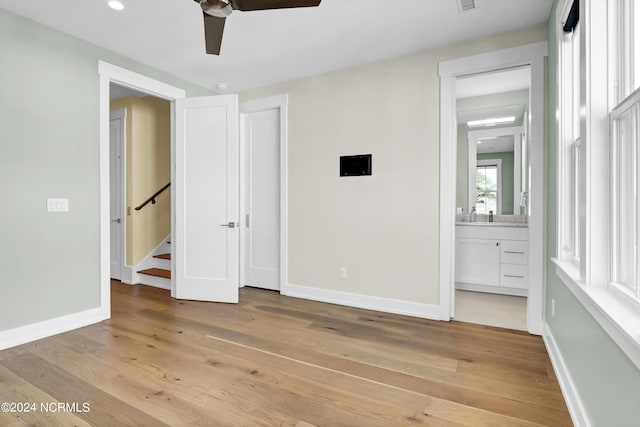 unfurnished bedroom with light wood finished floors, ensuite bath, visible vents, and baseboards