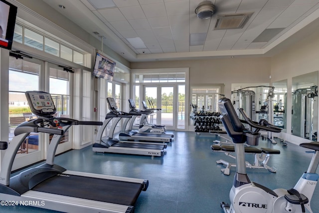 workout area with a paneled ceiling, french doors, visible vents, and a towering ceiling