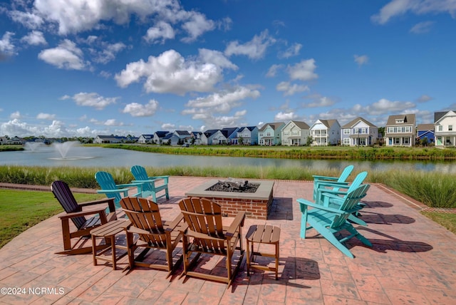 view of patio featuring an outdoor fire pit, a water view, and a residential view