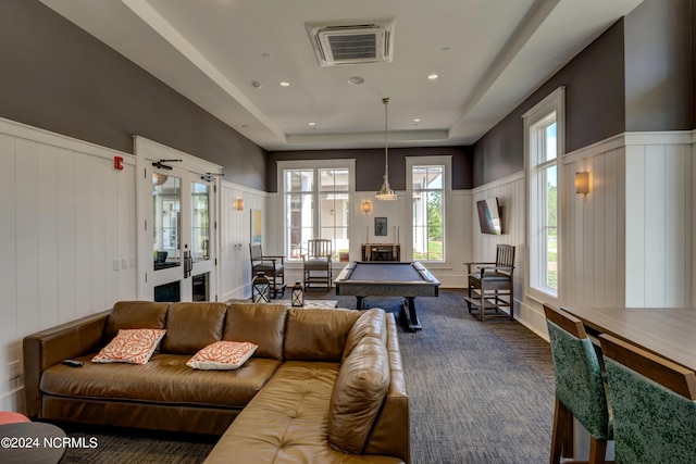 recreation room with a wainscoted wall, visible vents, dark carpet, and a raised ceiling