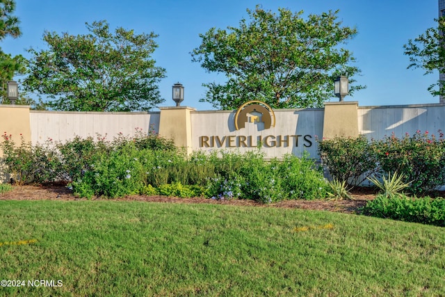 community sign featuring fence and a lawn