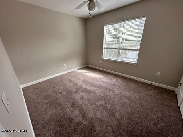 empty room with ceiling fan and carpet flooring