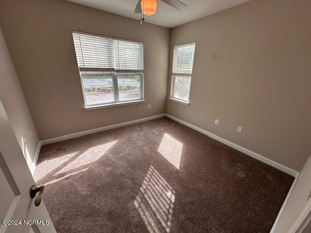 empty room with ceiling fan and carpet