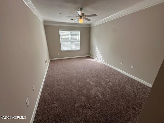 carpeted empty room featuring crown molding and ceiling fan