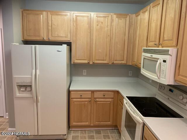 kitchen with white appliances and light brown cabinets