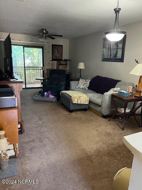 living room with carpet floors, a textured ceiling, and ceiling fan