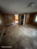 interior space with concrete flooring and wooden walls