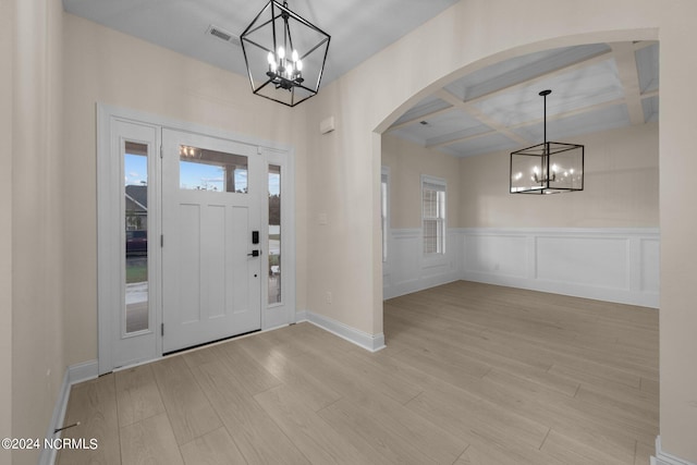 entrance foyer with light wood-type flooring, coffered ceiling, beam ceiling, and plenty of natural light