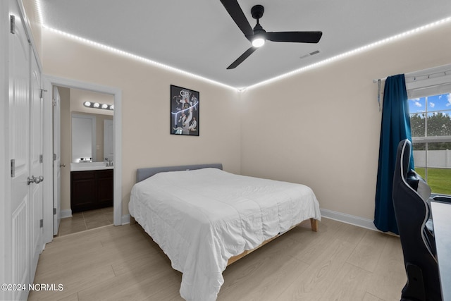 bedroom featuring connected bathroom, light hardwood / wood-style flooring, and ceiling fan