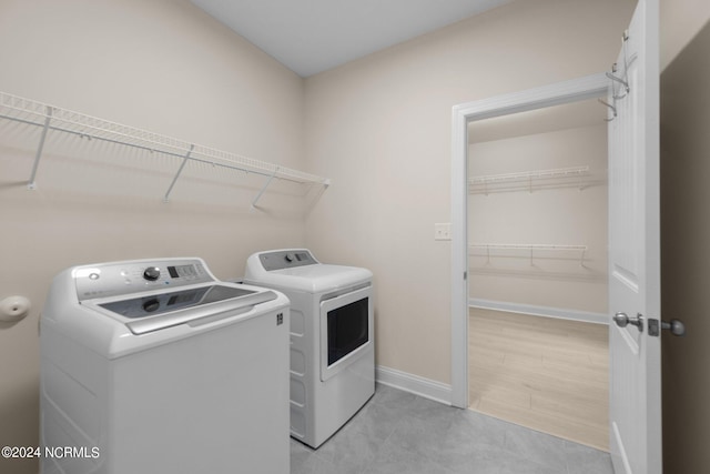 washroom with independent washer and dryer and light wood-type flooring