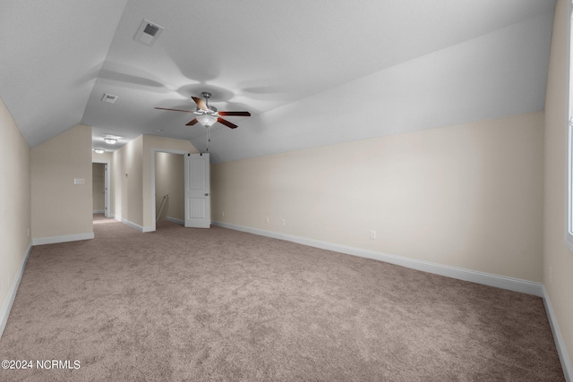 bonus room with vaulted ceiling, light carpet, and ceiling fan