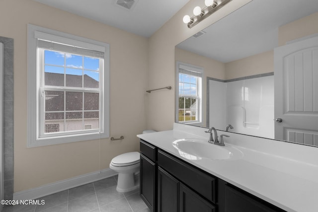 bathroom featuring toilet, a healthy amount of sunlight, vanity, and tile patterned flooring