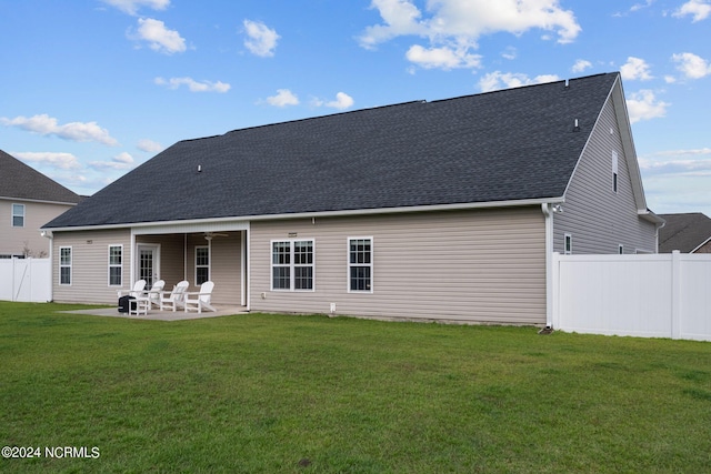 back of house featuring a patio area and a lawn