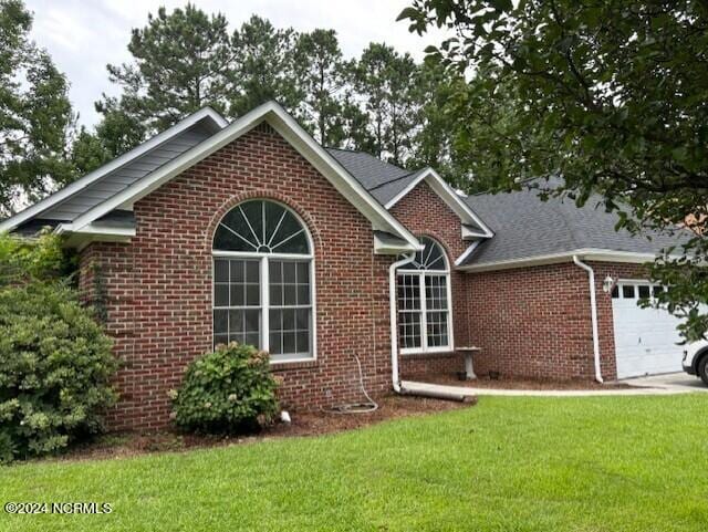 view of front of property with a front yard and a garage