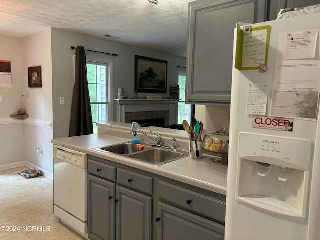 kitchen featuring gray cabinets, a textured ceiling, sink, and white appliances