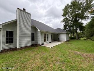 rear view of house featuring a patio and a yard