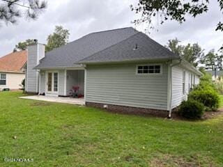 back of property featuring a patio area and a lawn